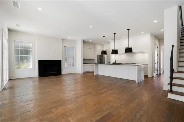 a kitchen with kitchen island a counter top space appliances and a ceiling fan