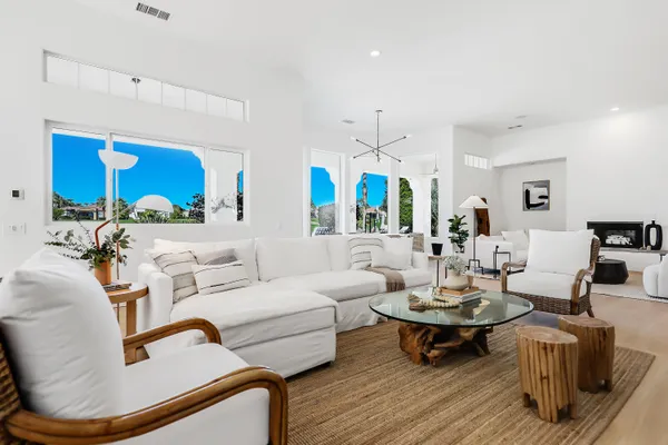 a living room with furniture kitchen view and a wooden floor