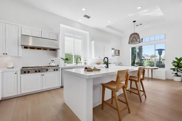 a kitchen with stainless steel appliances a table chairs and a refrigerator
