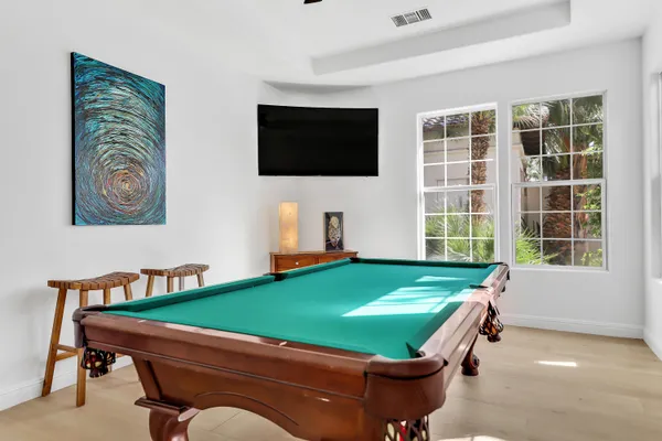 a room with pool table and windows