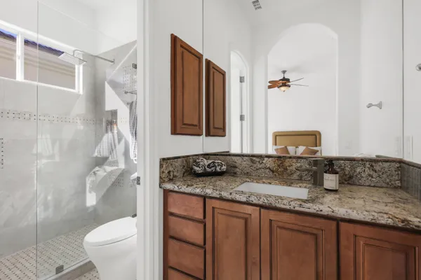 a bathroom with a granite countertop sink and a mirror