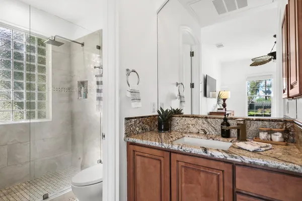 a bathroom with a granite countertop sink toilet and shower