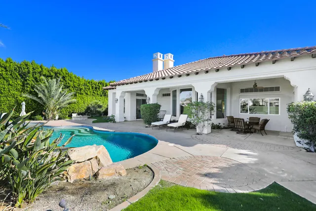 a view of a house with backyard patio and swimming pool