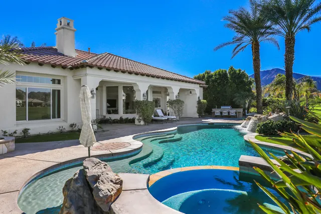 a view of a house with backyard swimming pool and sitting area