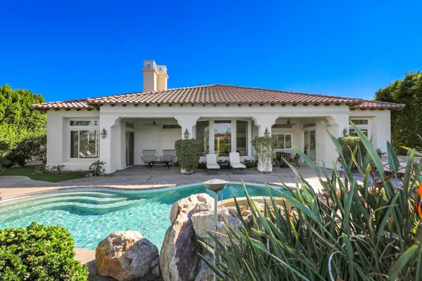 a view of a house with backyard and sitting area