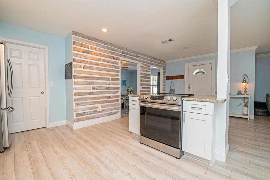 436 Orchis Road St. Augustine, FL 32086 - Photo 20 of 39 a kitchen with stainless steel appliances white cabinets and wooden floor