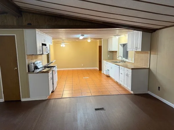 a kitchen with granite countertop a sink and a stove top oven