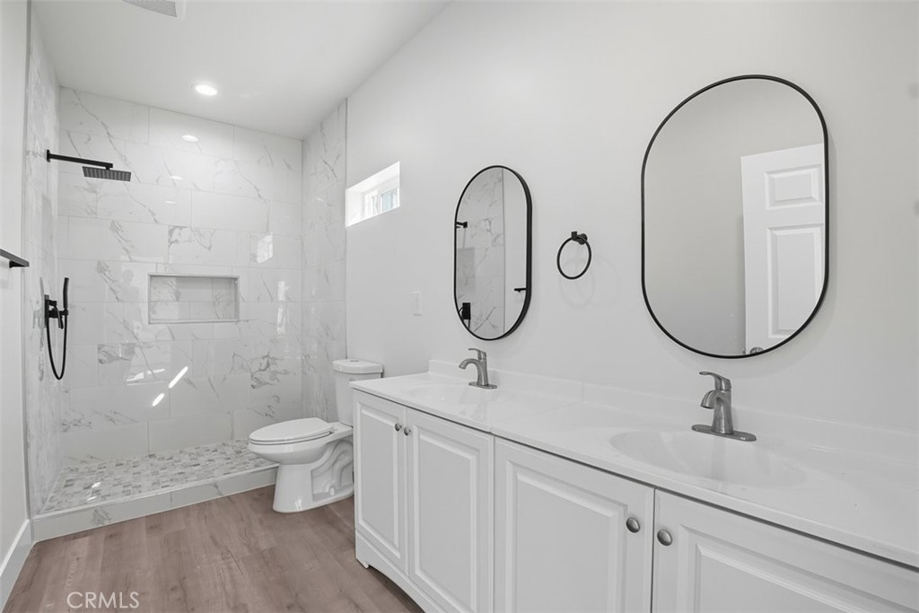 19258 Strathern Street Reseda, CA 91335 - Photo 18 of 36 a bathroom with a double vanity sink a toilet and a shower