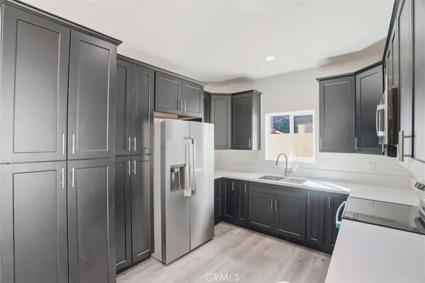 a view of a kitchen with a sink and a refrigerator