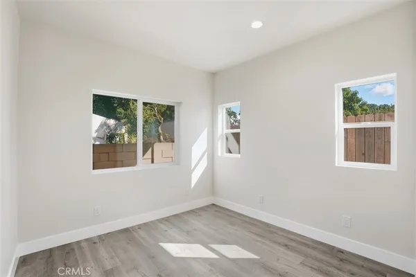 a view of an empty room with wooden floor