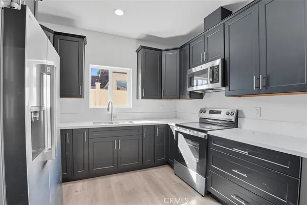 a kitchen with granite countertop a refrigerator and a sink