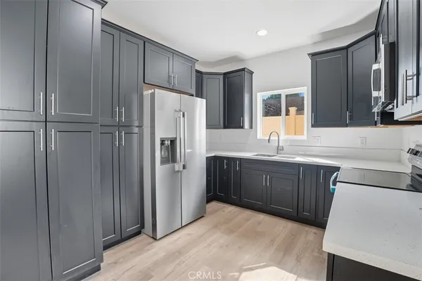 a kitchen with stainless steel appliances a refrigerator and a stove top oven