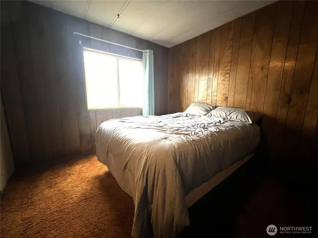 a bed sitting in a bedroom next to a window