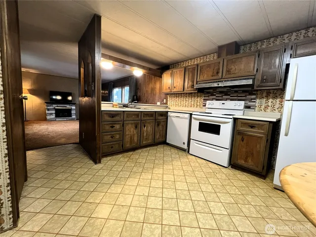 a kitchen with stainless steel appliances granite countertop a stove a sink dishwasher and a refrigerator