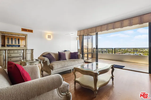 a view of a living room with floor to ceiling window and wooden floor