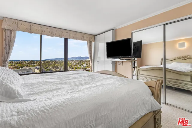 a bedroom with a bed and a flat tv screen on dresser