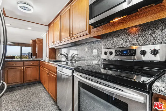 a kitchen with stainless steel appliances granite countertop a stove and a sink