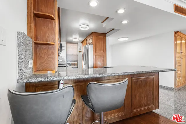 a kitchen with stainless steel appliances granite countertop a sink a stove and a refrigerator