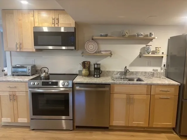a kitchen with stainless steel appliances granite countertop a stove and a microwave