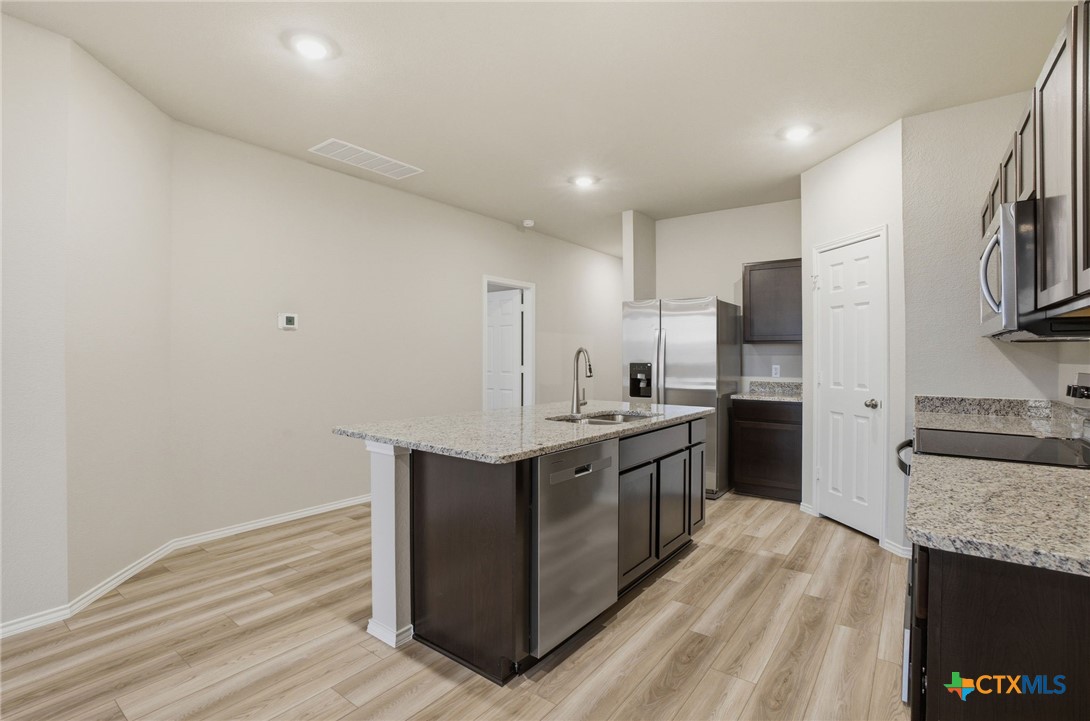 1126 Stone Vly Road, Unit B Temple, TX 76502 - Photo 11 of 26 a kitchen with stainless steel appliances granite countertop a stove and a refrigerator