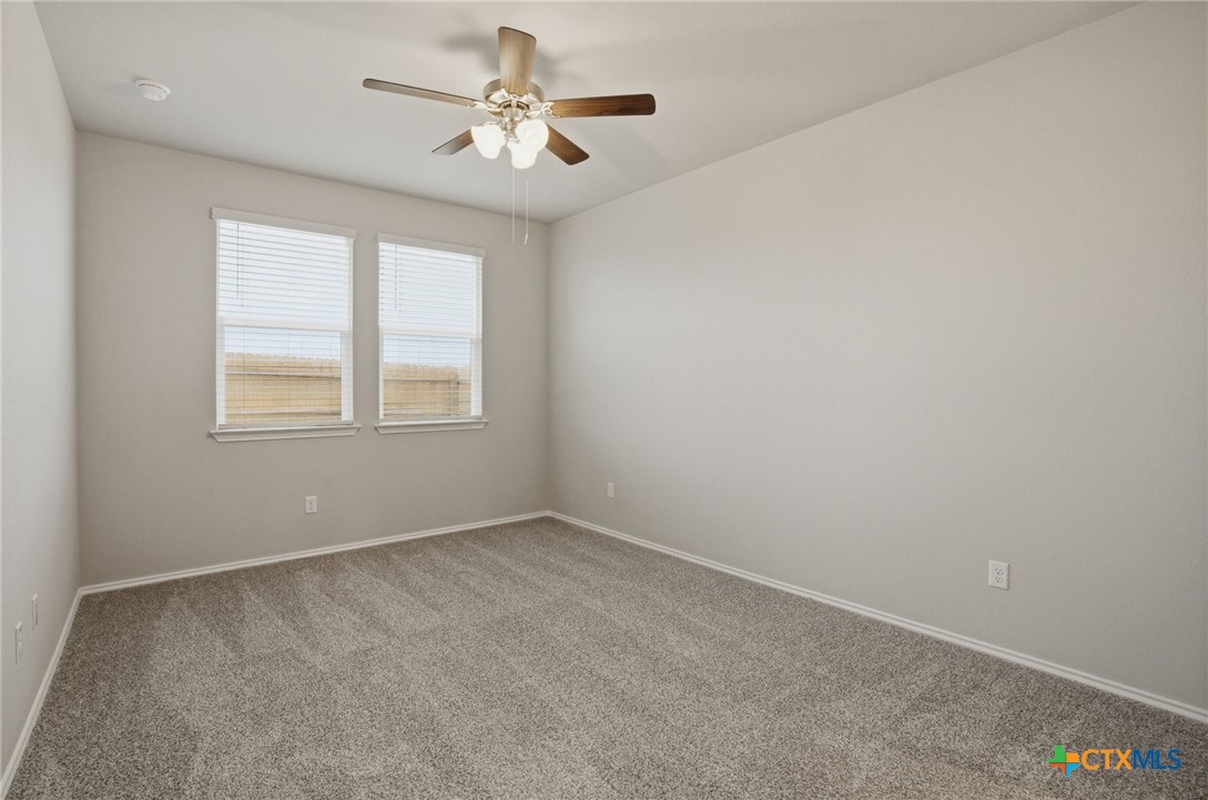 1126 Stone Vly Road, Unit B Temple, TX 76502 - Photo 19 of 26 an empty room with windows and fan