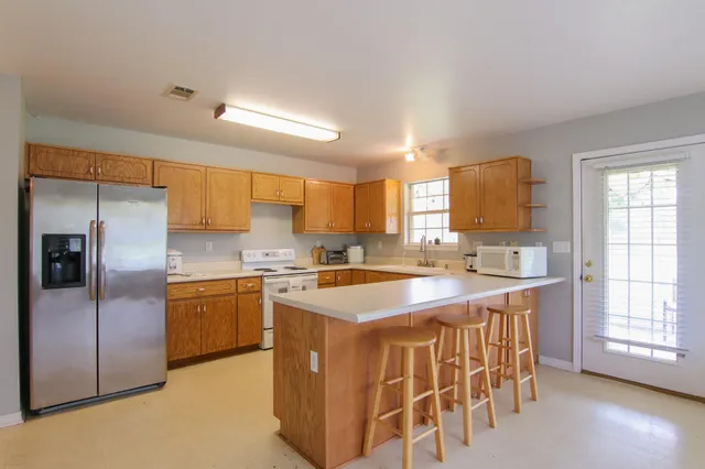 a kitchen with stainless steel appliances granite countertop a sink stove and refrigerator