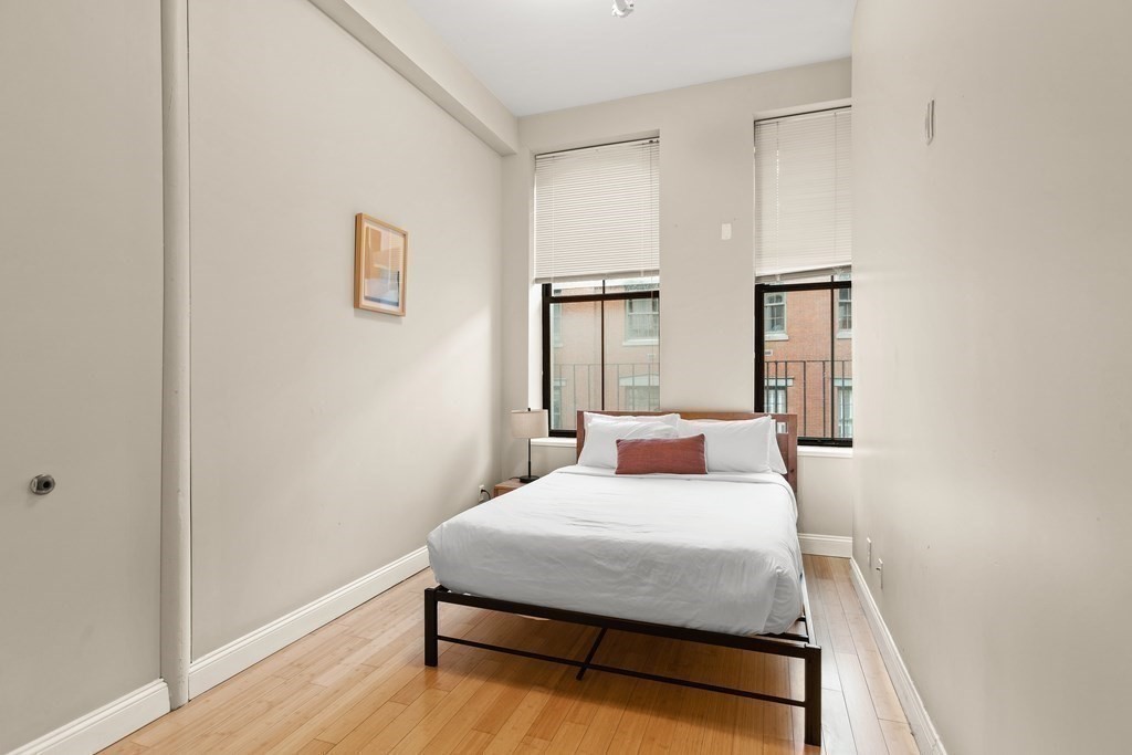 37 Temple Place, Unit 401 Boston, MA 02111 - Photo 1 of 7 a bedroom with a bed and a table
