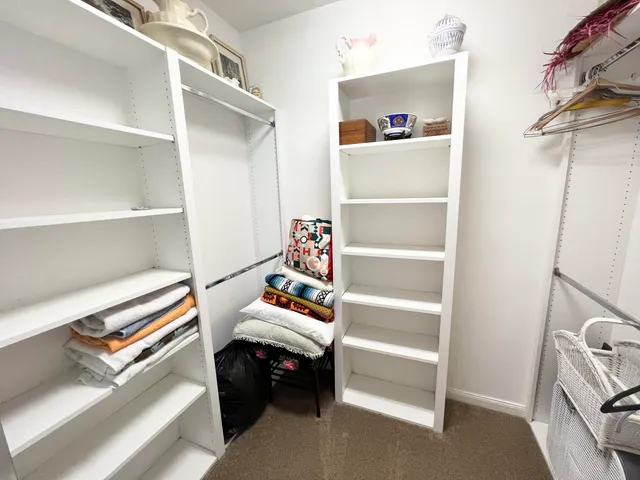 a view of walk in closet with clothes and shoes