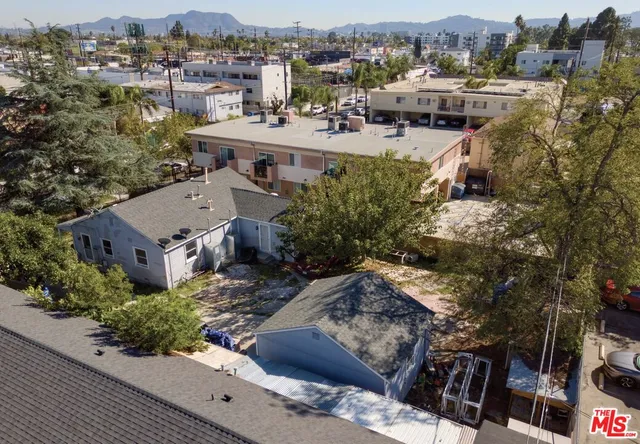 an aerial view of a house with a yard and mountain view in back