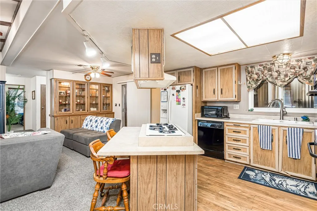 4000 Pierce Street, Unit 106 Riverside, CA 92505 - Photo 7 of 18 a kitchen with stainless steel appliances kitchen island granite countertop a stove a sink dishwasher and a dining table with wooden floor