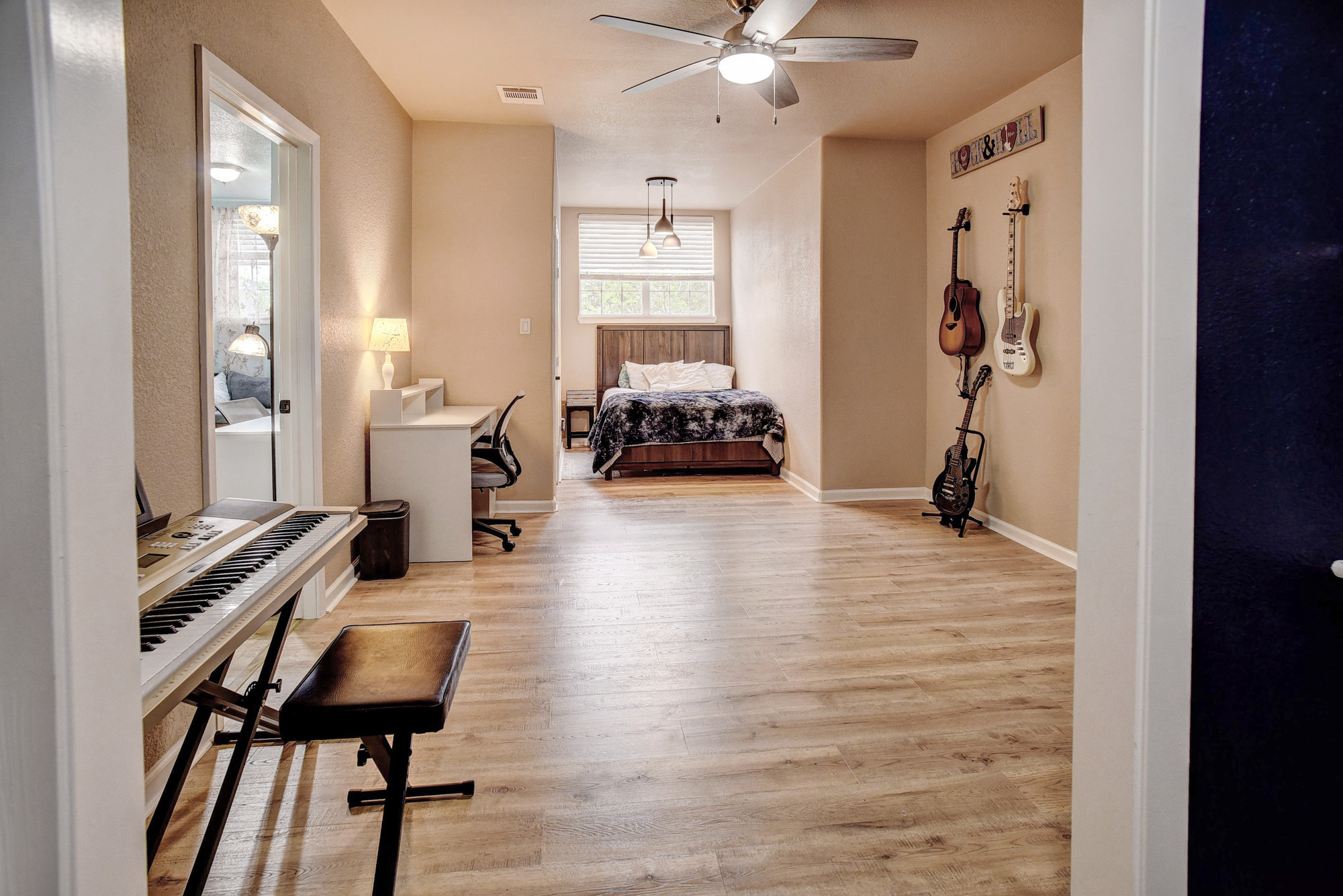 147 Spring Meadow Road Bastrop, TX 78602 - Photo 25 of 40 Open-concept room featuring wood-finish flooring, a ceiling fan with integrated lighting, and a window with horizontal blinds