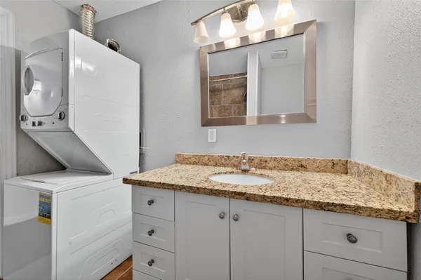 a bathroom with a granite countertop sink and a mirror