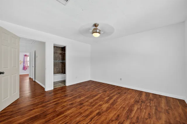 a view of empty room with wooden floor