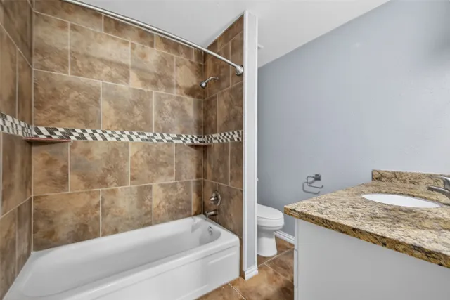 a bathroom with a granite countertop bathtub and shower
