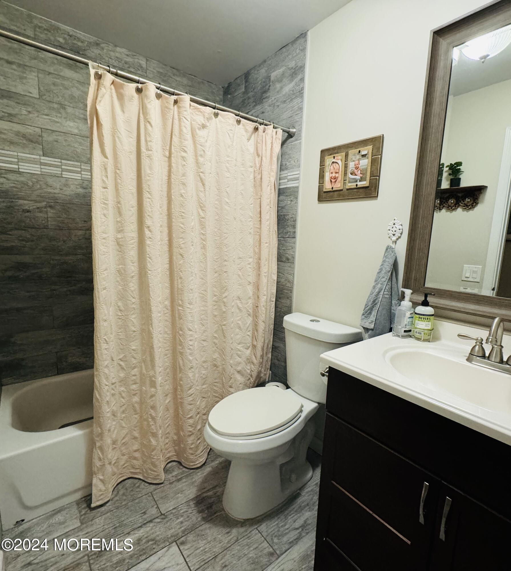 8 Old Farm Road Tinton Falls, NJ 07724 - Photo 13 of 24 a bathroom with a sink a toilet a mirror and shower curtain