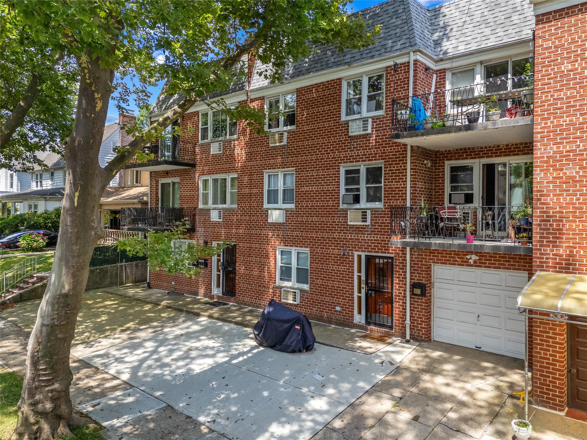85-45 Abingdon Road Queens, NY 11415 - Photo 3 of 13 a view of a brick house with many windows next to a road