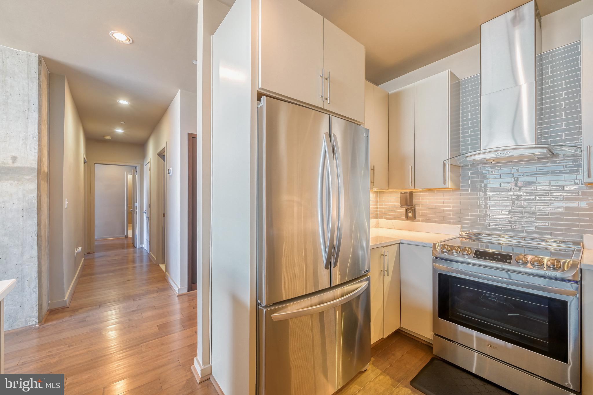 1200 Steuart Street, Unit 713 Baltimore, MD 21230 - Photo 12 of 43 a kitchen with granite countertop a refrigerator stove and cabinets