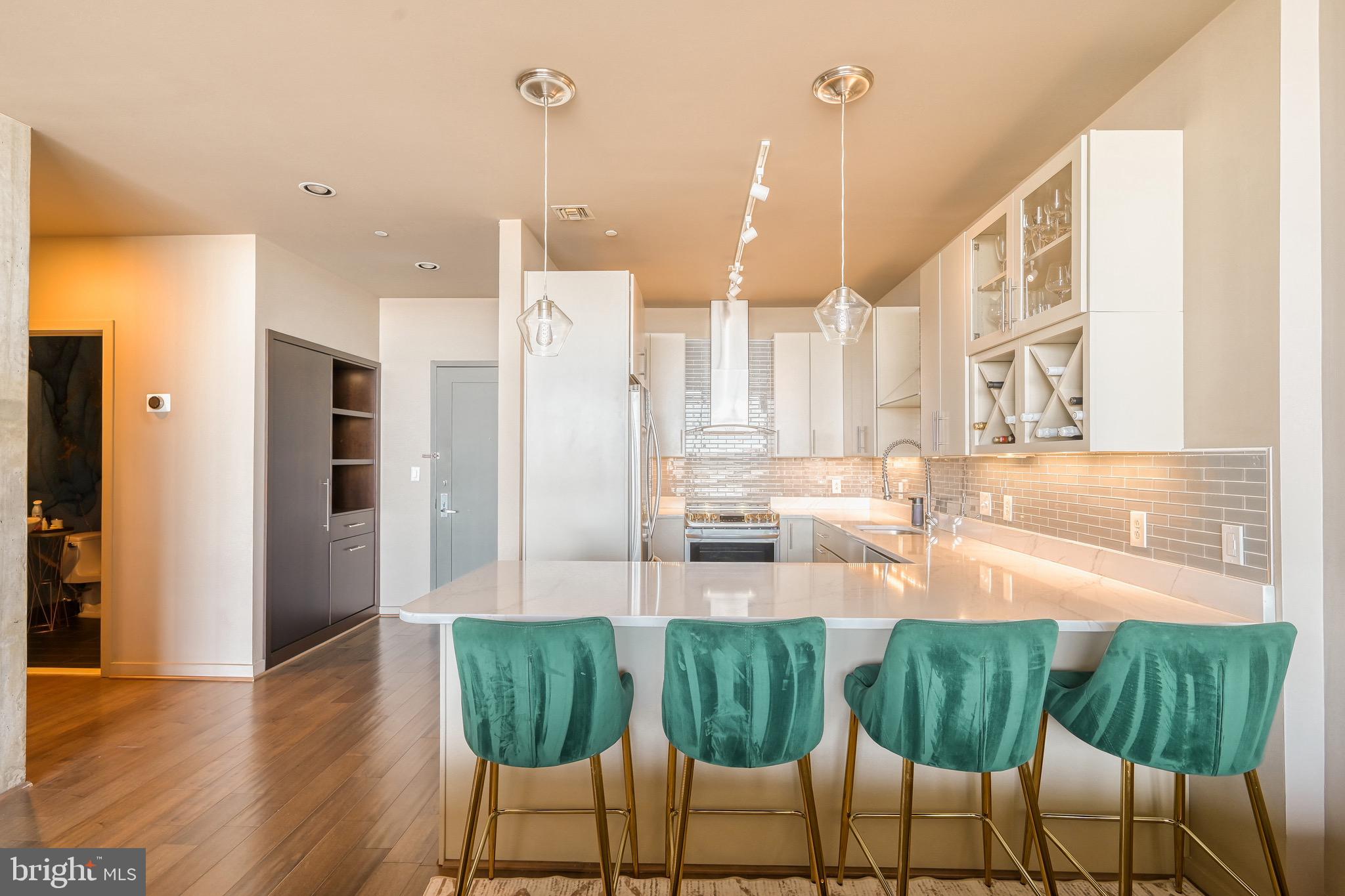 1200 Steuart Street, Unit 713 Baltimore, MD 21230 - Photo 13 of 43 a kitchen with stainless steel appliances granite countertop a table chairs and a large window