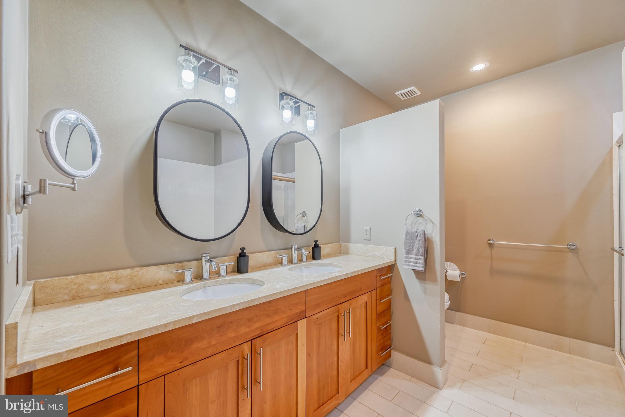 1200 Steuart Street, Unit 713 Baltimore, MD 21230 - Photo 24 of 43 a bathroom with a granite countertop double vanity sink and a mirror