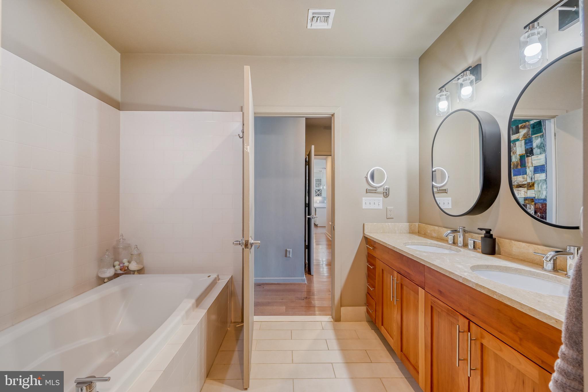1200 Steuart Street, Unit 713 Baltimore, MD 21230 - Photo 25 of 43 a bathroom with a double vanity sink mirror and bathtub