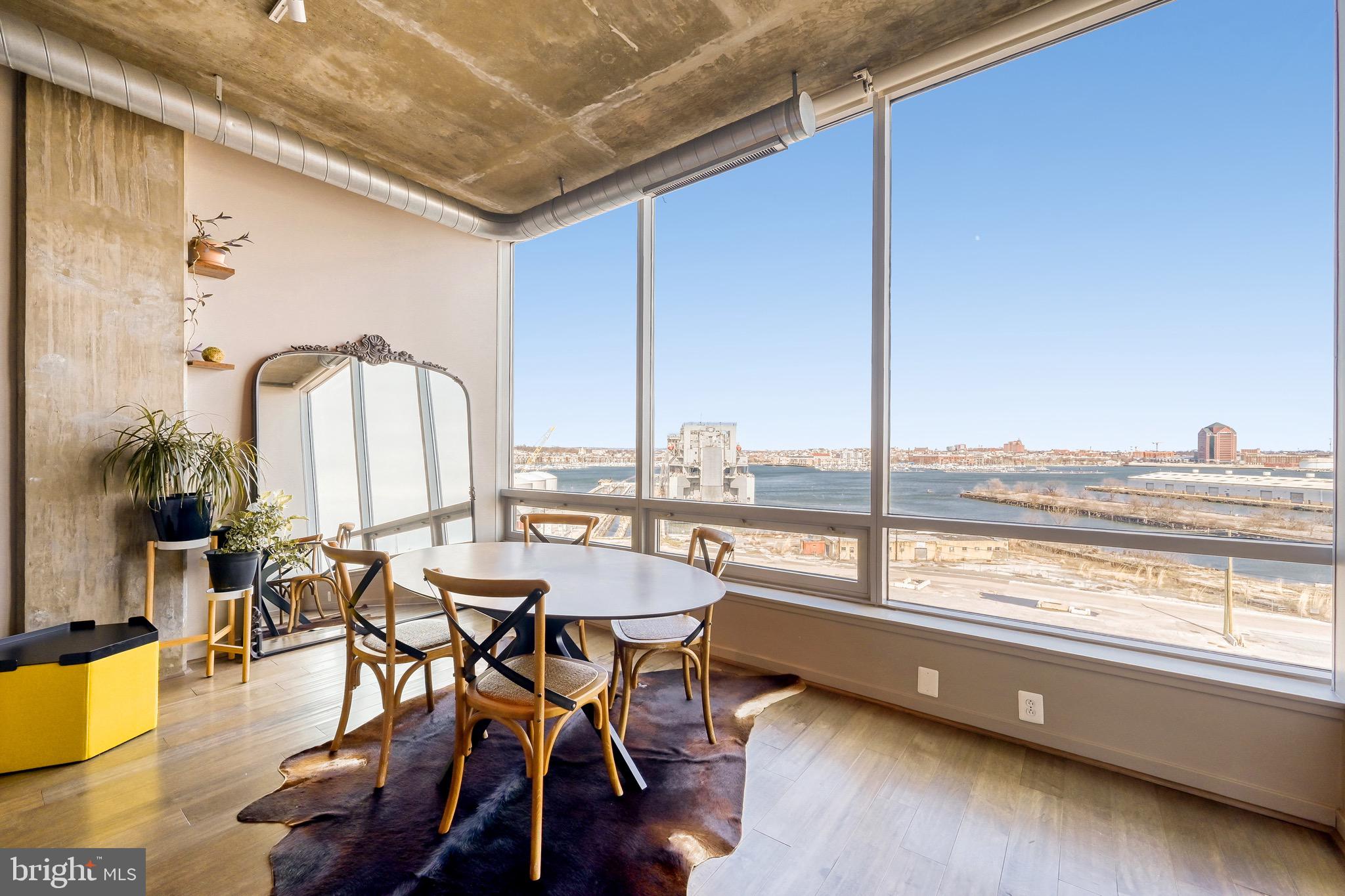 1200 Steuart Street, Unit 713 Baltimore, MD 21230 - Photo 7 of 43 a view of a dining room with furniture window and wooden floor