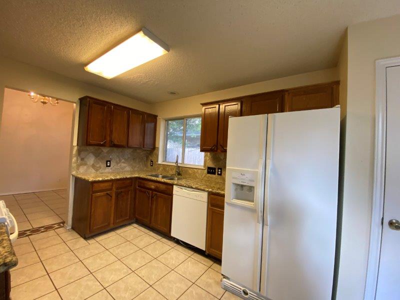 1903 Balsam Way Round Rock, TX 78665 - Photo 4 of 21 A well-equipped kitchen features solid wood cabinetry and tile flooring throughout.