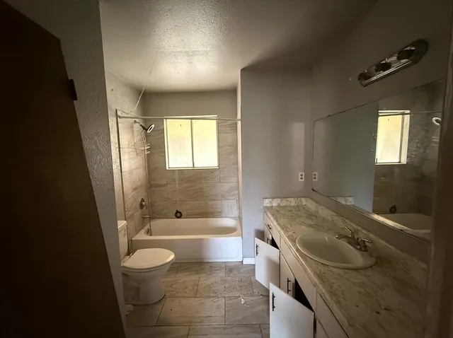 a bathroom with a sink and mirror with bathtub