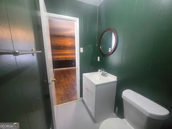 a bathroom with a toilet sink and mirror