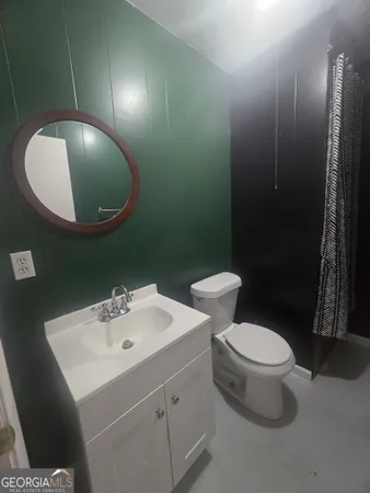 a bathroom with a toilet and a mirror