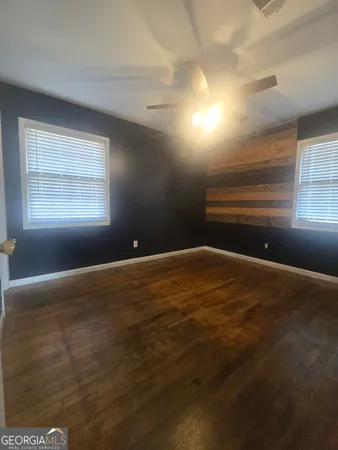 an empty room with kitchen view and windows
