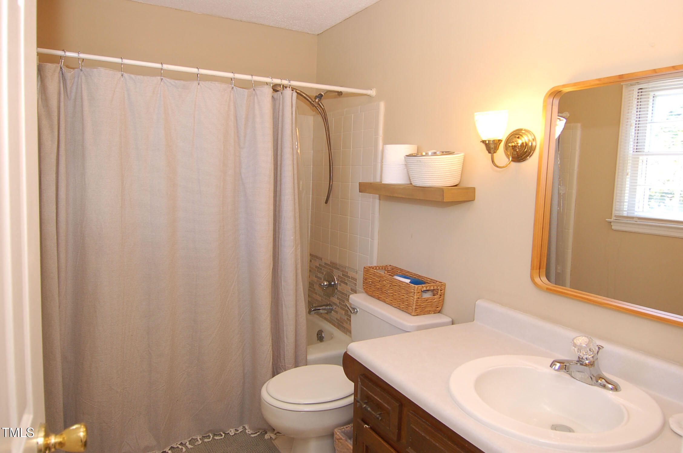 3414 Bellevue Road Raleigh, NC 27609 - Photo 13 of 20 a bathroom with a sink a toilet and shower curtain