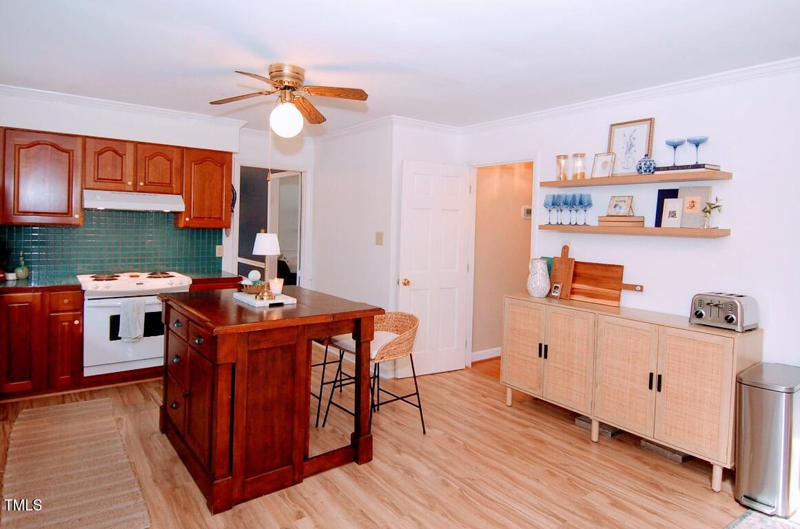3414 Bellevue Road Raleigh, NC 27609 - Photo 6 of 20 a kitchen with stainless steel appliances granite countertop a stove a sink dishwasher and a dining table with wooden cabinet