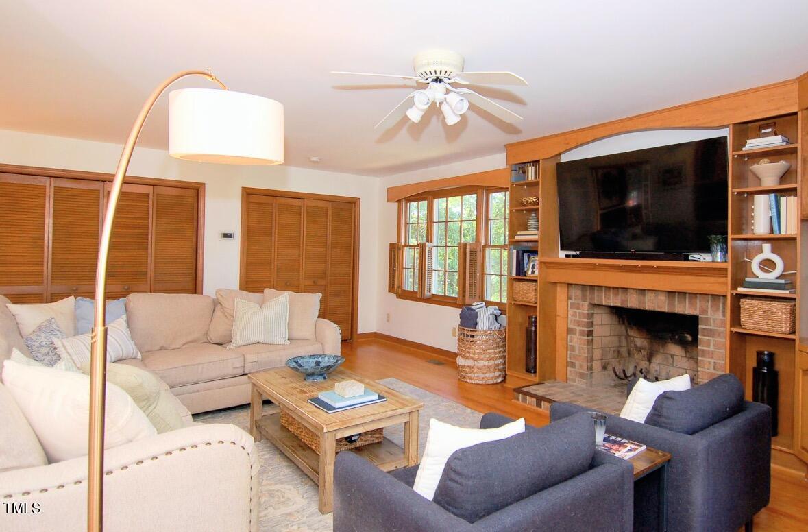 3414 Bellevue Road Raleigh, NC 27609 - Photo 8 of 20 a living room with furniture a flat screen tv and a fireplace