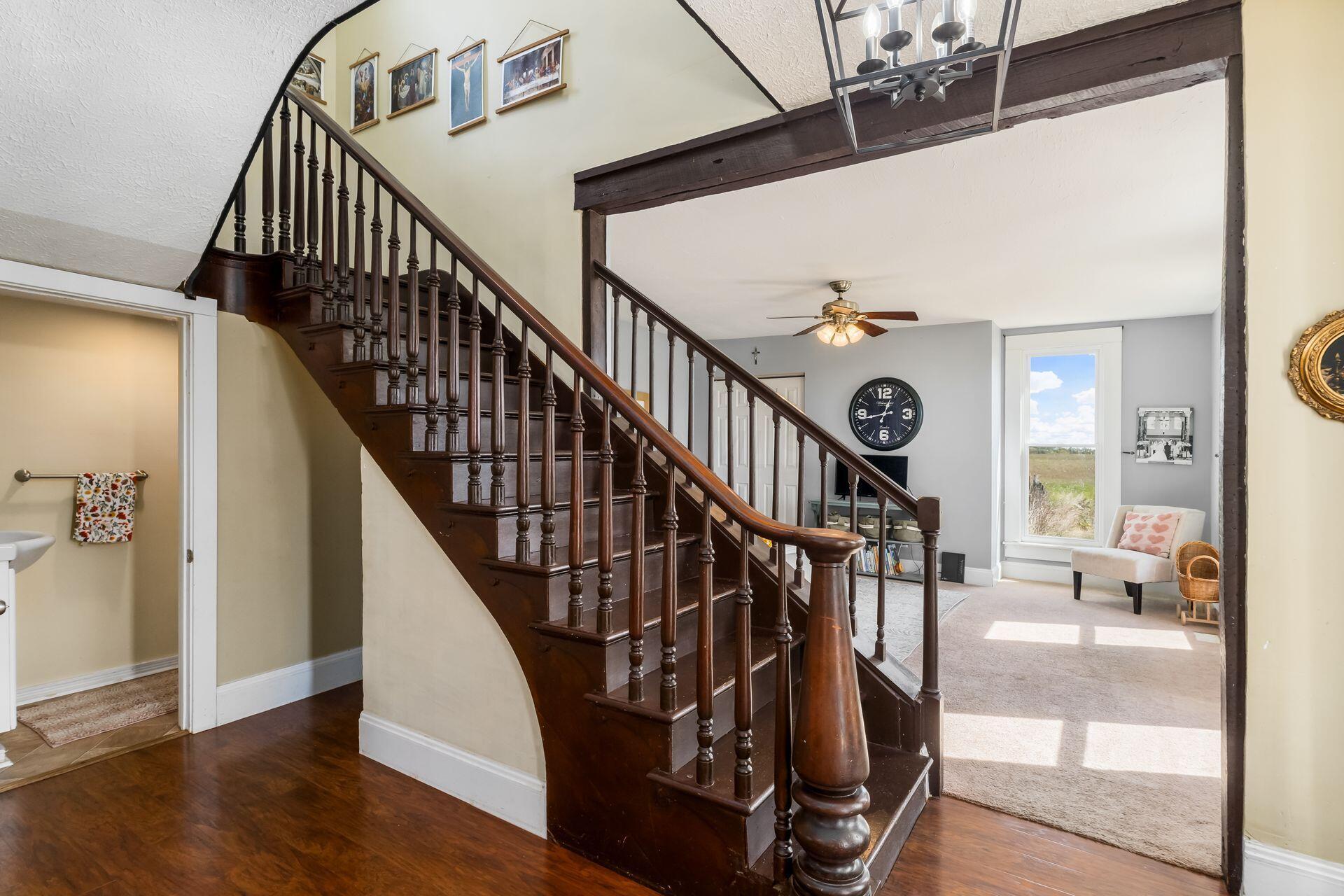 Front foyer with wooden staircase, laminate flooring, and charm throughout.